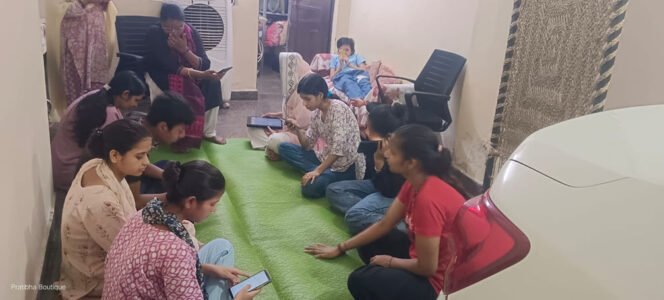 A group practising with mobile phones during a digital literacy session, seated indoors