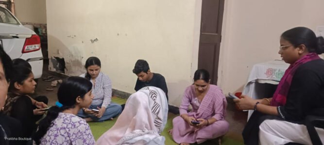 Women seated together on the floor during a mobile phone and digital literacy session