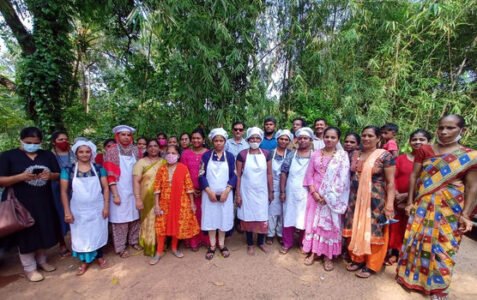 Group of trainees wearing aprons and caps posing together outdoors